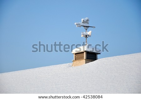 wind vane on snowy roof