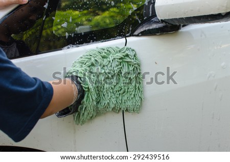 Car Wash with green cloth to wipe the car.