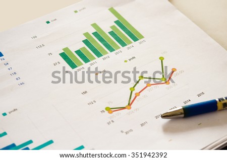 Financial graphs analysis and pen.