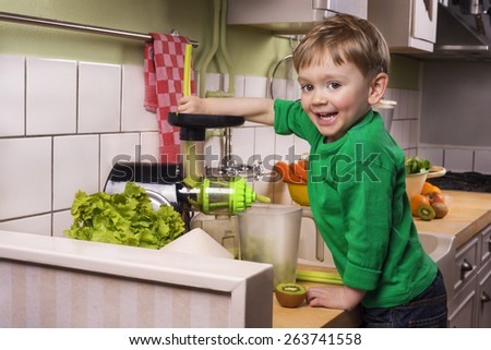 Happy toddler making green juice