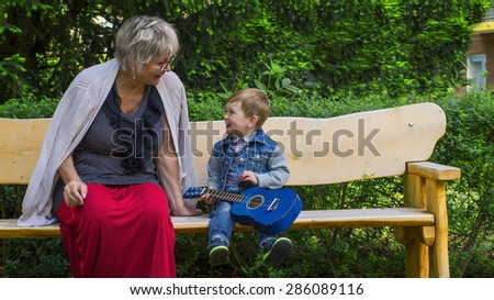 Grandmother and grandson singing and playing in a park
