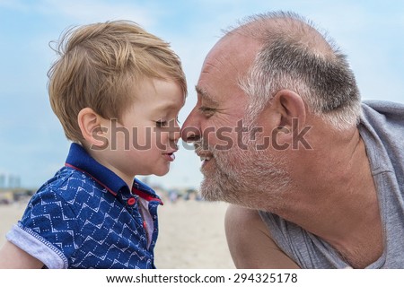 Grandfather and grandson having fun on the beach