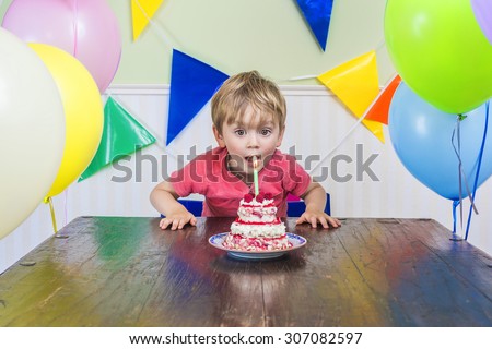 Adorable kid blowing out the candle on his birthday cake