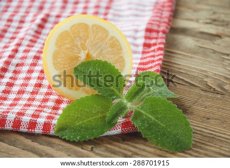 lemon and mint on a red white napkin on a wooden background