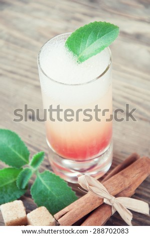 drink in a glass with mint cinnamon and sugar on wooden background color toning of