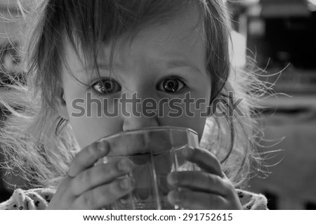 Black and white baby girl drinking from a cup