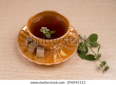Tea with flowers of peppermint. Tea with mint in a golden circle. Curative tea with mint.