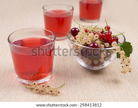 The berry juice in a glass. Berries in a glass bowl. The juice of the red and white currants. Cherry juice.