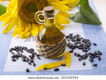 Sunflower oil with sunflower seeds. Decanter with sunflower oil and seeds. Sunflower seeds and oil decanter. Scattering seeds with sunflower oil.
