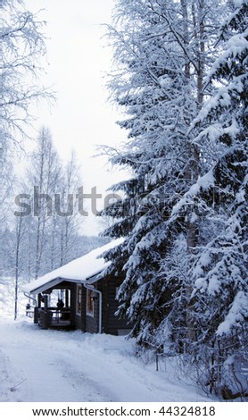 wooden cottage in winter forest covered by snow
