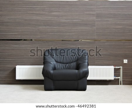 Alone black chair with radiator in minimalist interior