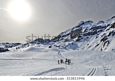 Winter Pyrenees Mountains of ski resort with cross-country  passes in Spanish and French border. Light cloudy sky with the sun is at background