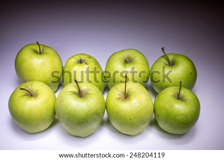 Eight green apples painted with light