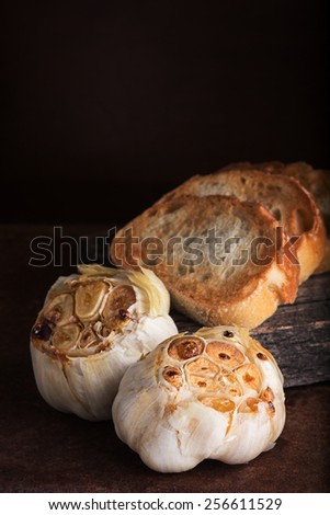 Roasted garlic heads on rustic surface