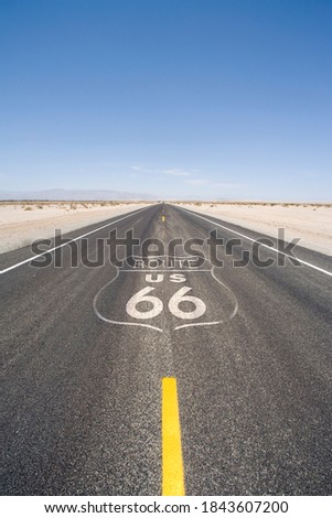 Vertical shot of an empty remote desert highway on a sunny day.