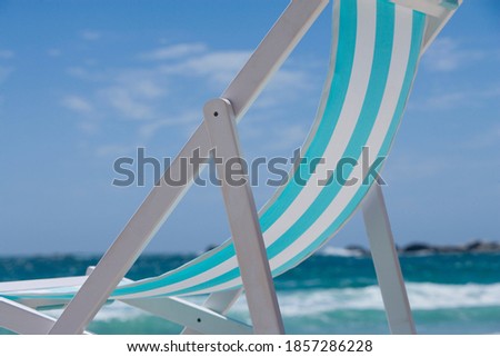 Horizontal close up shot of one deck chair kept on a beach on a bright, sunny summer day