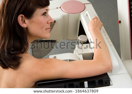 Horizontal head and shoulder profile shot of a woman having a breast scan in an hospital.