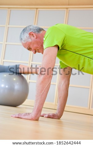 A low angle view of a senior adult man exercising in a gym to stay fit