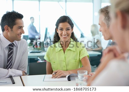 A portrait of a smiling businesswoman having a meeting with her co-workers in the conference room
