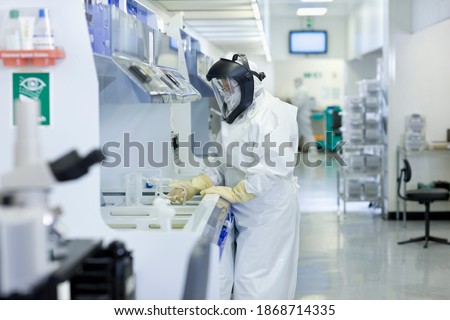 A horizontal side view of a Scientist in a clean suit working in the silicon wafer manufacturing laboratory