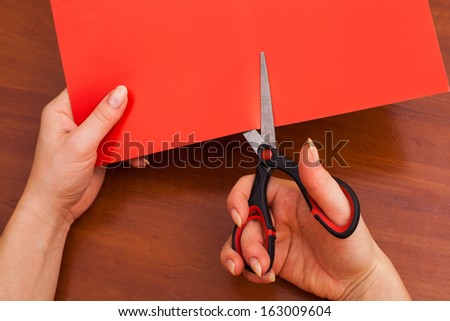 Woman\'s hand cutting paper