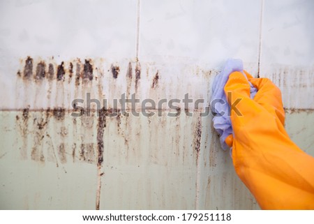Cleaning dirty old tiles in a bathroom