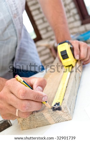 A woodworker measures the mark for his cut