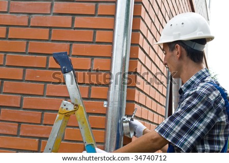 Man installing  rain gutter system