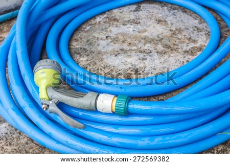 blue plastic garden hose pipe connected with spraying head