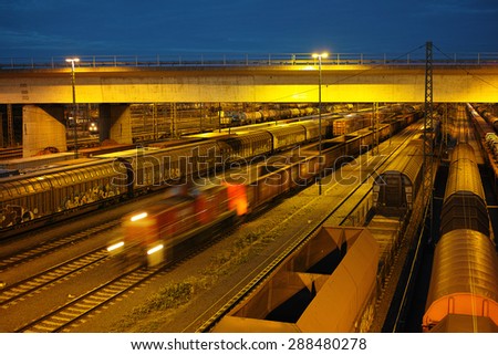 switch yard with trains, wagons, cargo at night