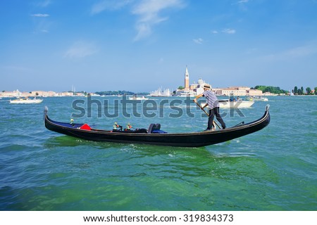 Gondolier on a gondola on the Grand Canal in Venice, Italy. Gondola\'s are a major mode of touristic transport in Venice