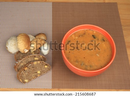 Goulash mushrooms in bowl on wooden table with fresh mushrooms sliced bread.