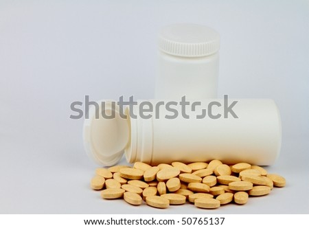 White pill bottle with pills on white background.