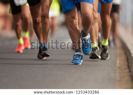 Marathon runners running on city road, group of runners