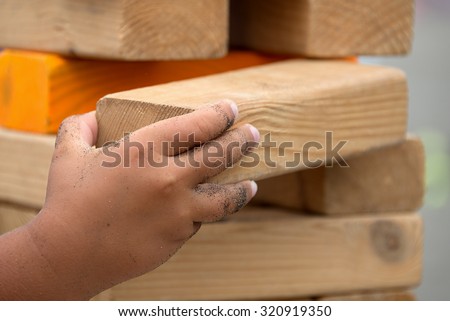 Child playing with the wood game (jenga) in the beach