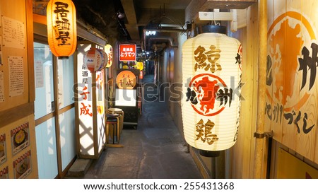 TOKYO, TOKYO, JAPAN AUGUST 5, 2014: Small alley located under the JR rail tracks. Several Izakayas are located on this place, marked by the lanterns hanging outside the shops.