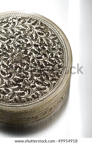 Floral patterned antique metal case on white background