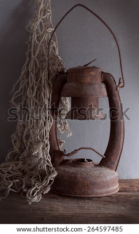 still life with old rusty kerosene lamp and fishing Net