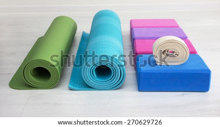 varicolored iyengar yoga props blocks, strap, roller and carpet