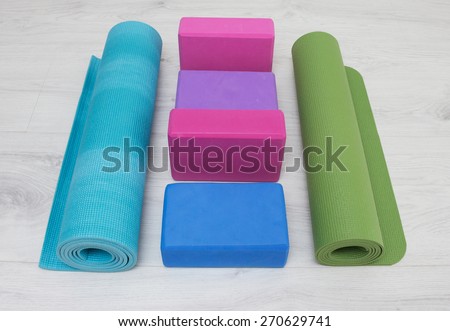 varicolored iyengar yoga props blocks, strap, roller and carpet