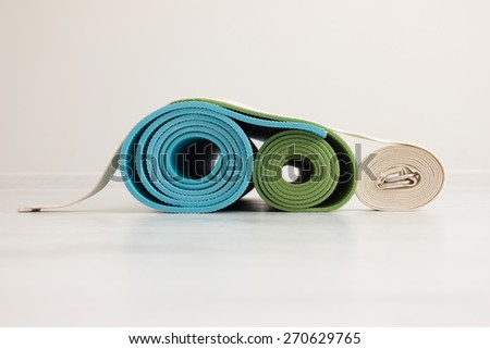 two yoga iyengar mats green and blue colors and white belt