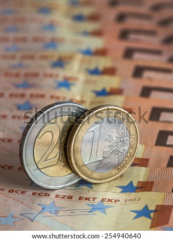 One and two euro, which is located among many banknotes of Europe