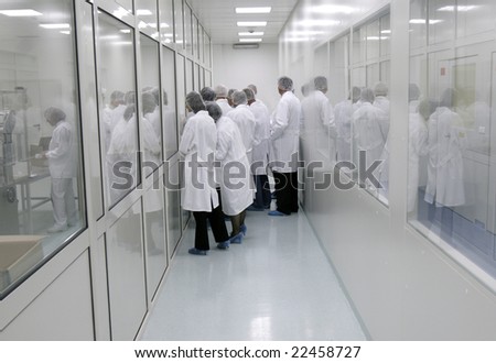 visitors in white coats in interior of a pharmaceutical industry