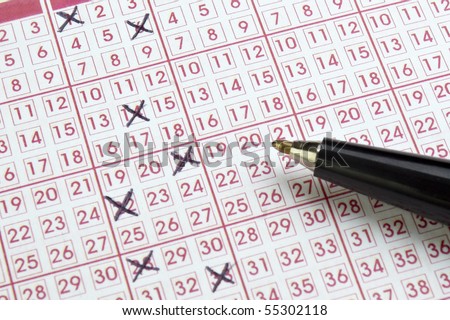 close up of lottery ticket and pen