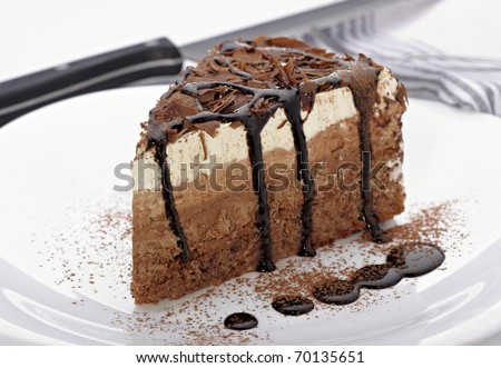 close up of a chocolate cream cake on white plate