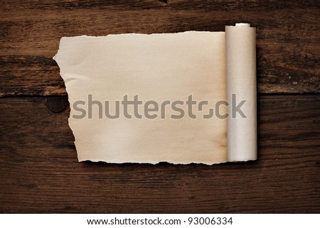 close up of  a curled paper on a wooden background