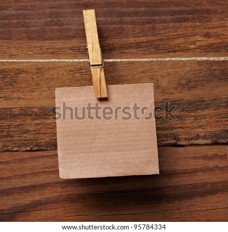 close up of  a note paper and clothes peg on a wooden background