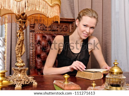 Beautiful woman with book in the antique parlor.