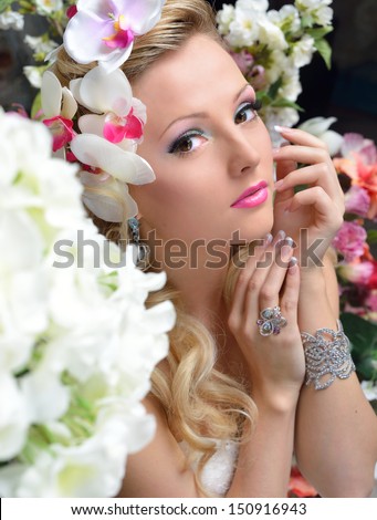 Portrait of the beautiful chic woman around the flowers.