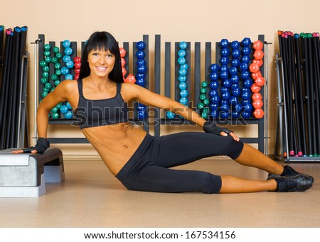Beautiful woman doing exercises in the sport club.